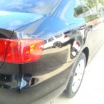 Before and after photographs of a damaged black Volkswagon Jetta that was repaired by Elite Paint & Body Shop in West Palm Beach, Florida.